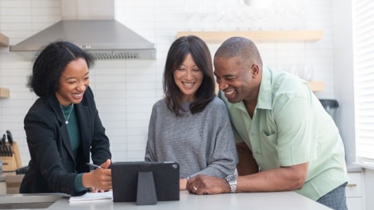 Financial advisor talking with their clients in a kitchen.